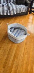 Set Of Striped Towels In A Woven Laundry Basket