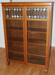 Wood Bookcase With Glass Doors Which Include Stained Glass Accents.