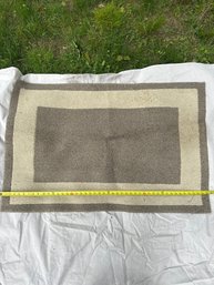 Rectangular Beige And Taupe Area Rug With Geometric Border Design.