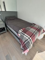 Single-size Gray Wooden Bed Frame With Matching Nightstand And Bedding.