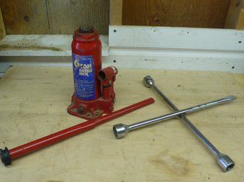 A 6-Ton Hydraulic Bottle Jack With Operating Handle And A Chrome Four-Way Lug Wrench