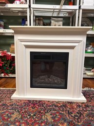 A Freestanding Electric Fireplace With A White Mantel.