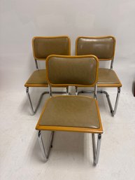 Three Vintage Marcel Breuer Cesca Chairs With A Chrome-plated Cantilevered Frame, Wooden Trim, And Tan Upholst