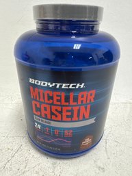 A Container Of BodyTech Micellar Casein Protein Powder In Rich Chocolate Flavor.