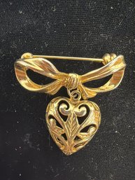 Vintage-style Gold Tone Brooch Features A Hanging Heart Pendant Attached To A Bow Ribbon