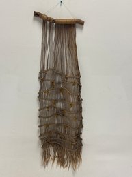 Handcrafted Macrame Wall Hanging, Featuring A Natural Wooden Branch And Woven Jute Or Fiber Cord To Create A R