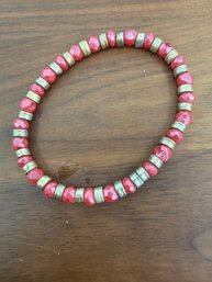 Stretch Bracelet Featuring Alternating Red Faceted Beads And Metallic Spacer Beads