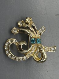 Vintage Coro Bow Shaped Brooch Featuring Gold-tone Metal With Clear And Blue Rhinestone Accents
