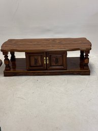 Vintage-style Solid Wood Coffee Table Features A Brown Stain, Carved Cabinet Door Details, And Decorative Turn
