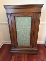 Traditional Wood Accent Cabinet Featuring A Warm Brown Finish, Tiered Crown Molding, And A Sage Green Center D