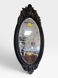 Oval Black Carved Mirror, Floral And Scroll Crest. 26' W × 56½' H.