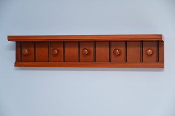 Wooden Wall-mounted Coat Rack With Five Round Pegs.