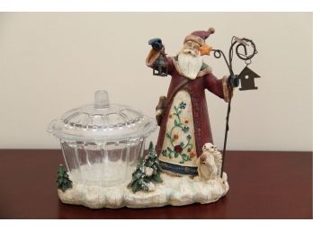 A Santa Holding Lantern Display With Covered Dish