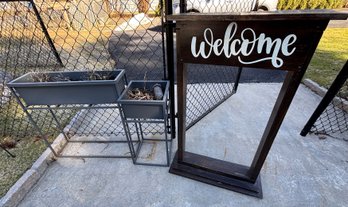 Two Planters And A Welcome Sign