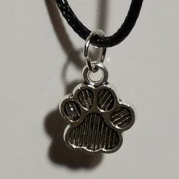 Silver-toned Charm Necklace With A Paw Print Pendant On A Black Cord (NM)