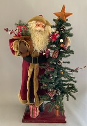 31 Santa In Red Felt Outfit On Wood Base Holding Packages & A Christmas Tree