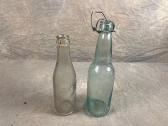 Two Glass Bottles, Clear Bottle And Aqua Bottle With Wire Bale Closure