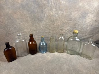 Collection Of Eight Vintage Glass Bottles, Varying In Shapes And Color